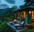 Cozy Coorg homestay surrounded by lush greenery, with mountain views, outdoor lounge chairs, and warm interior lighting.