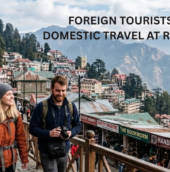 Crowded hill-station street with domestic and foreign tourists, mountain views, and colonial buildings. Text overlay reads, “Foreign Tourists Down, Domestic Travel at Record High.”