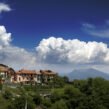 Property in Kasauli surrounded by lush greenery, hillside homes, mountains, and a scenic lake.