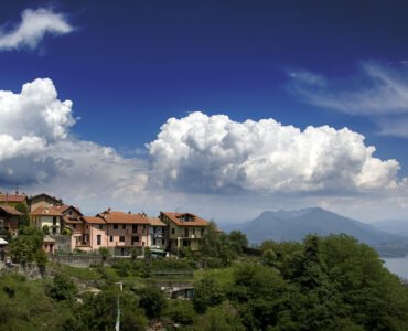 Property in Kasauli surrounded by lush greenery, hillside homes, mountains, and a scenic lake.