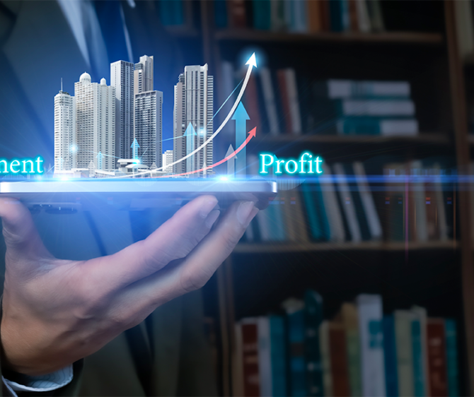 Hand holding a tablet displaying a digital real estate investment concept, with high-rise buildings, rising arrows, and the words “Investment” and “Profit.”