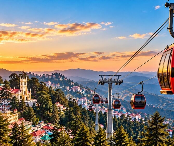 Shimla ropeway with red cable cars overlooking the city, pine forests, and Himalayan mountains at sunset.